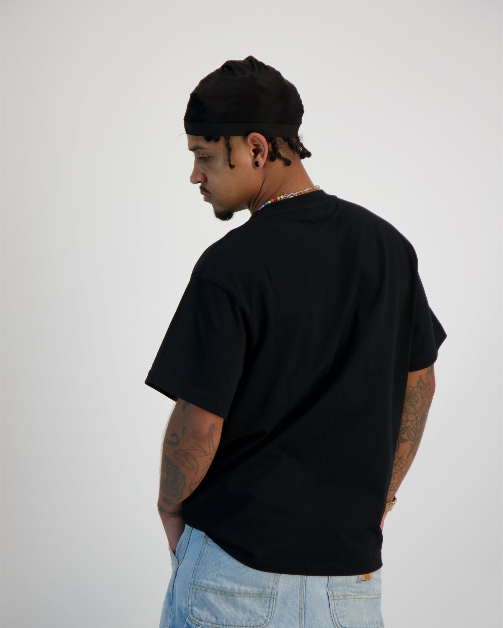 Sauce Model wearing a T -Shirt in Black from the back shot