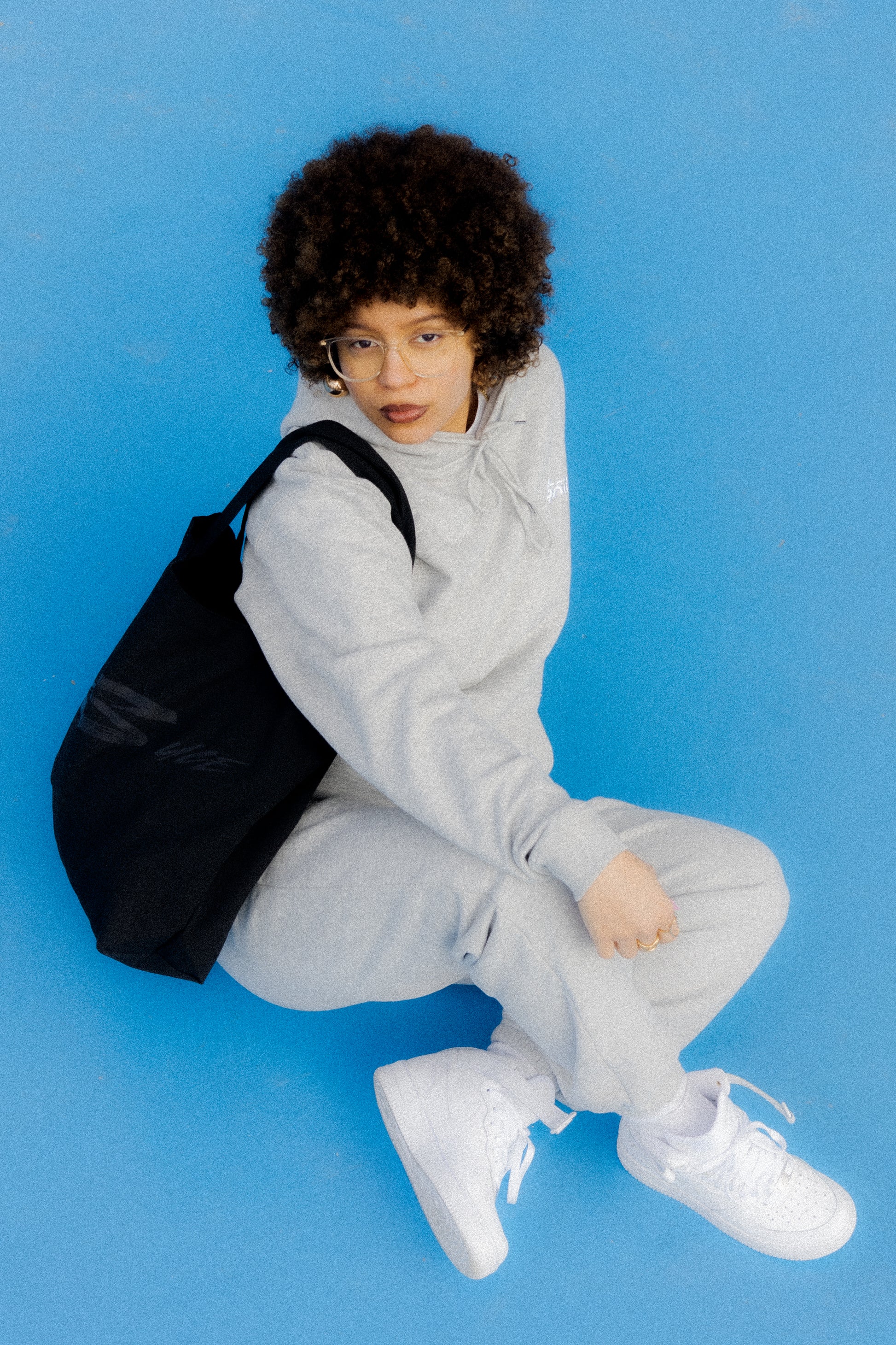 Sauce Tote Bag and model posing with it on the floor