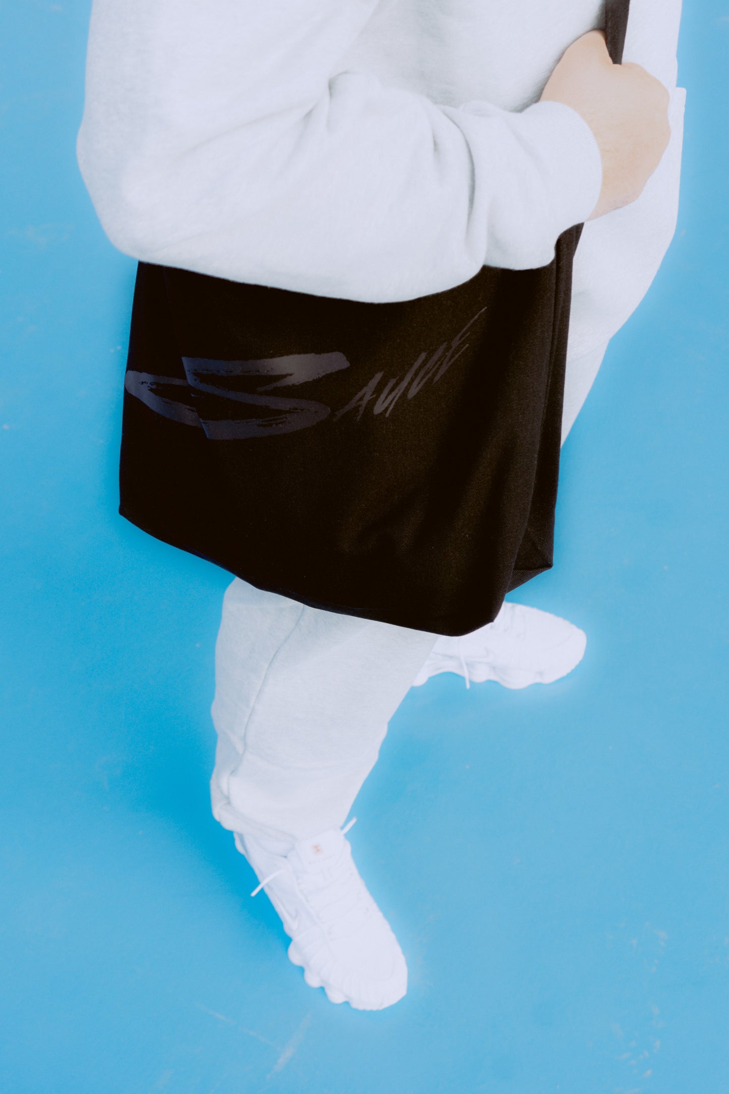 Sauce Tote Bag and model posing with it from the side