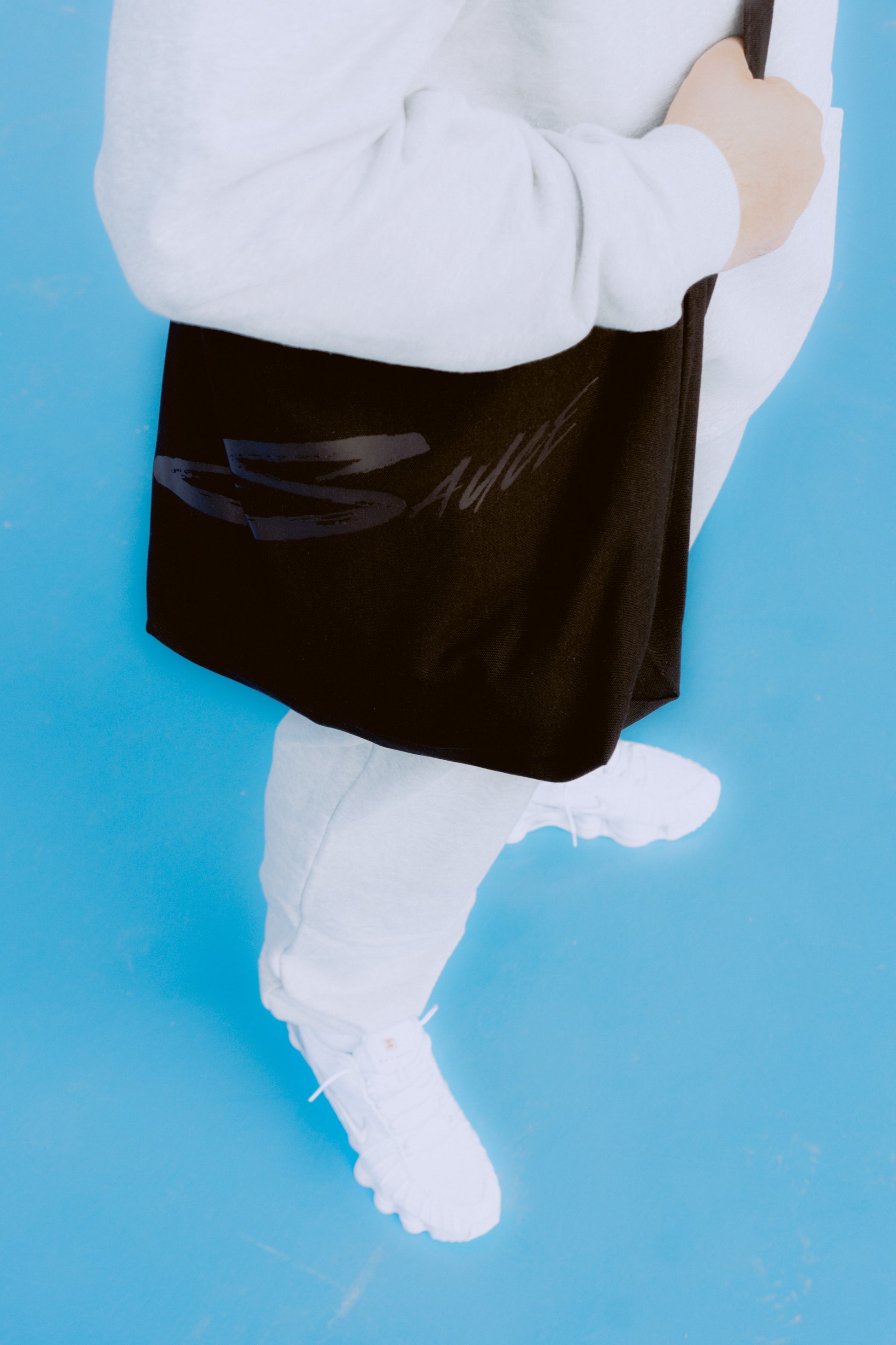 Sauce Tote Bag and model posing with it from the side