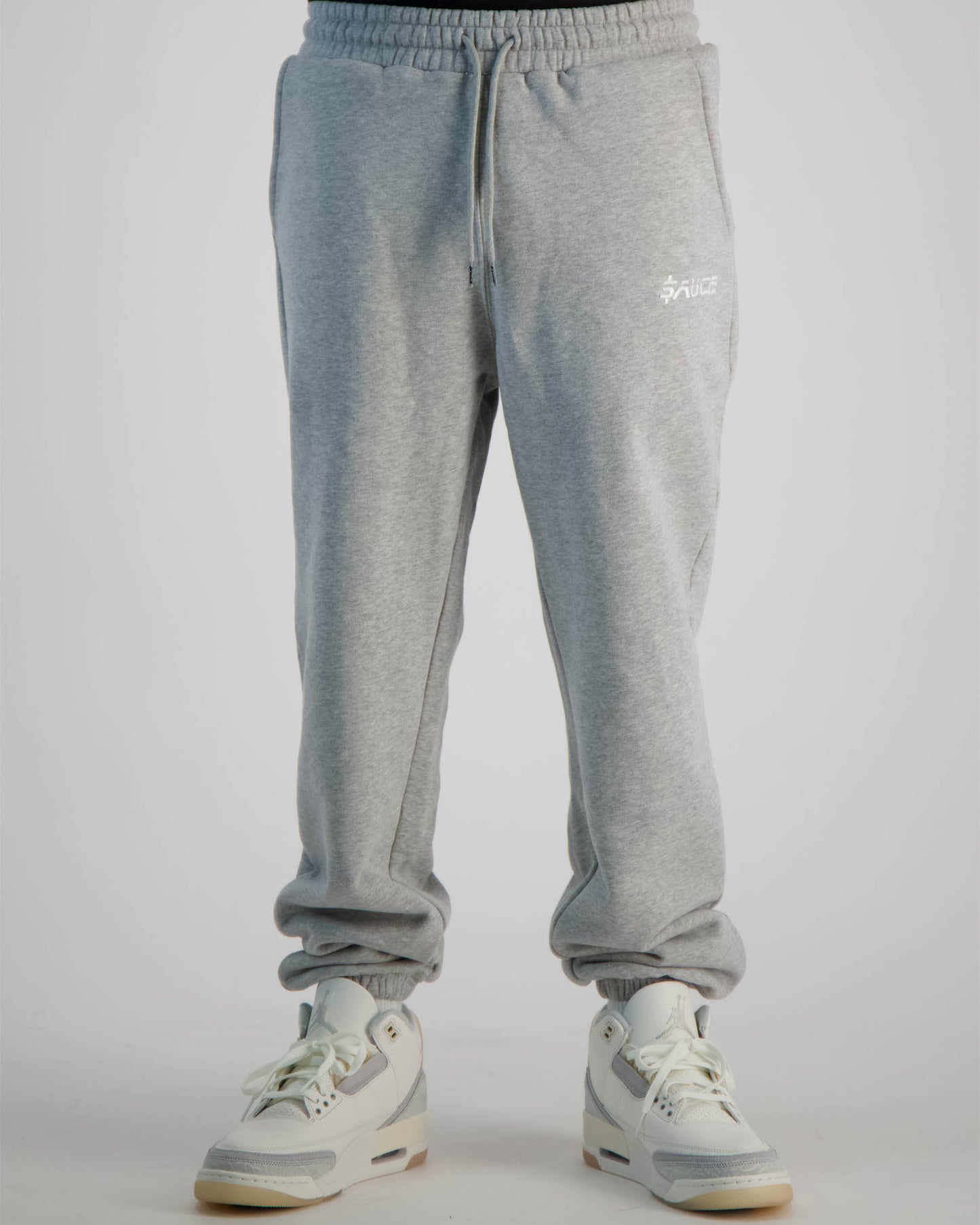 Sauce Tracksuit Pants in Grey and a Model wearing it shot from the front